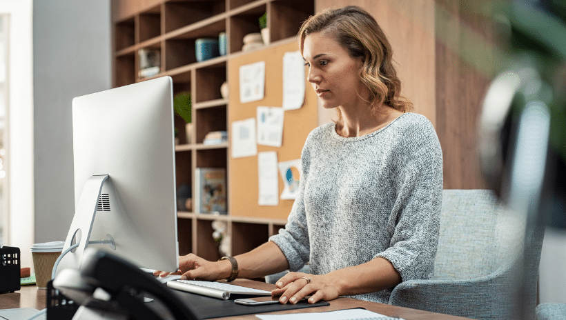 Woman working in office looking at computer monitor